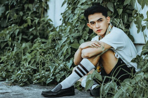 A Man Sitting Beside the Green Plants