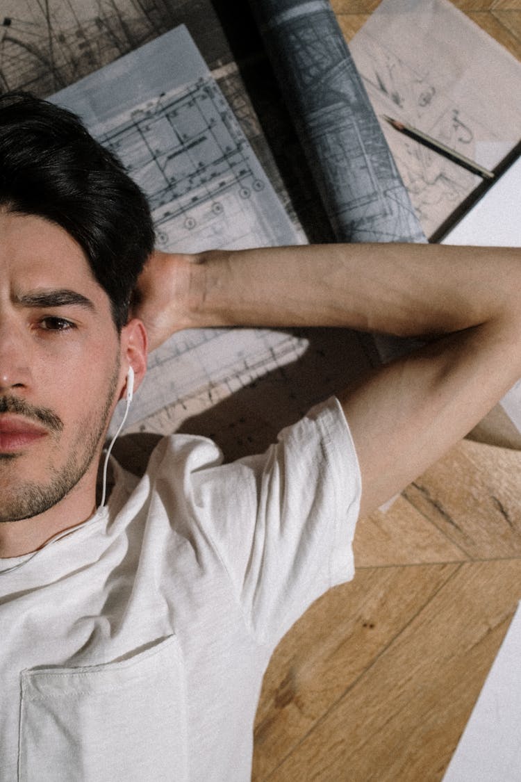 Adult Man Laying On Floor Among Drawings