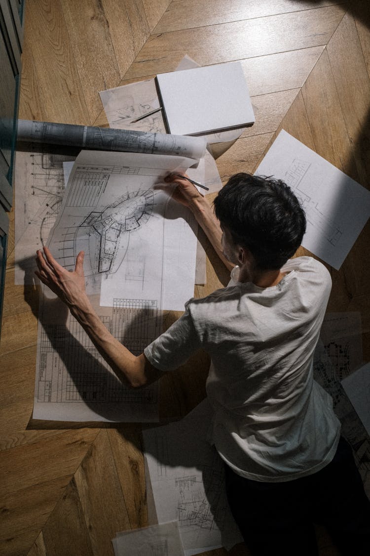 Adult Man Laying On Floor And Holding A Drawing