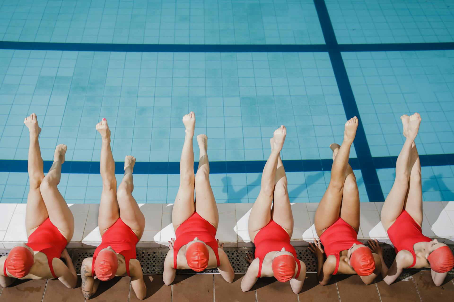 Women in One-Piece Swimsuits Exercising on Edge of Swimming Pool