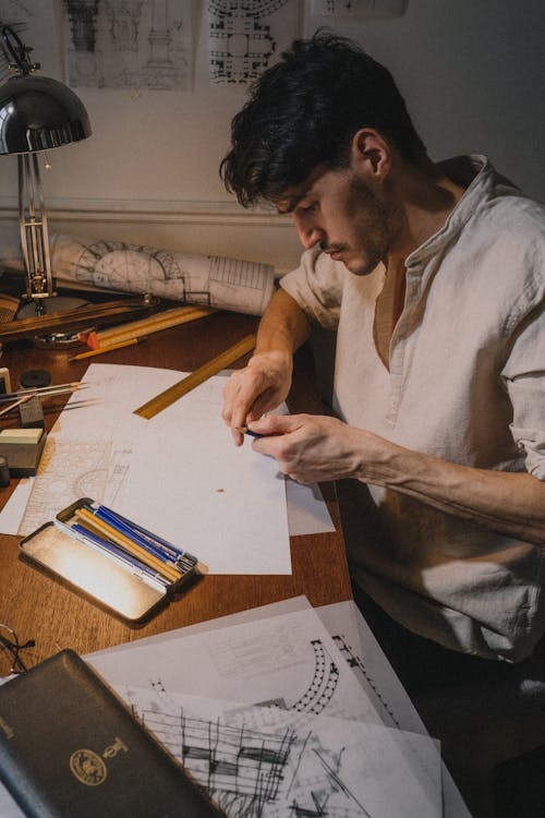 Adult man sitting by deck with drawings