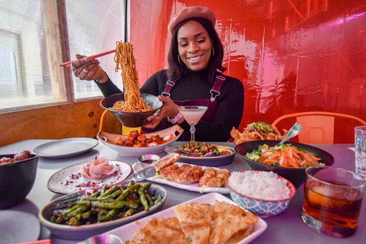 Smiling Woman Sitting At Table With Food