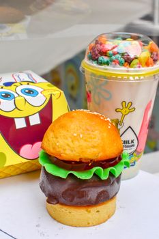 SpongeBob themed dessert featuring vibrant burger-shaped cake and fruity milkshake.