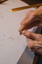 Close up on mans hands while tempering pencil