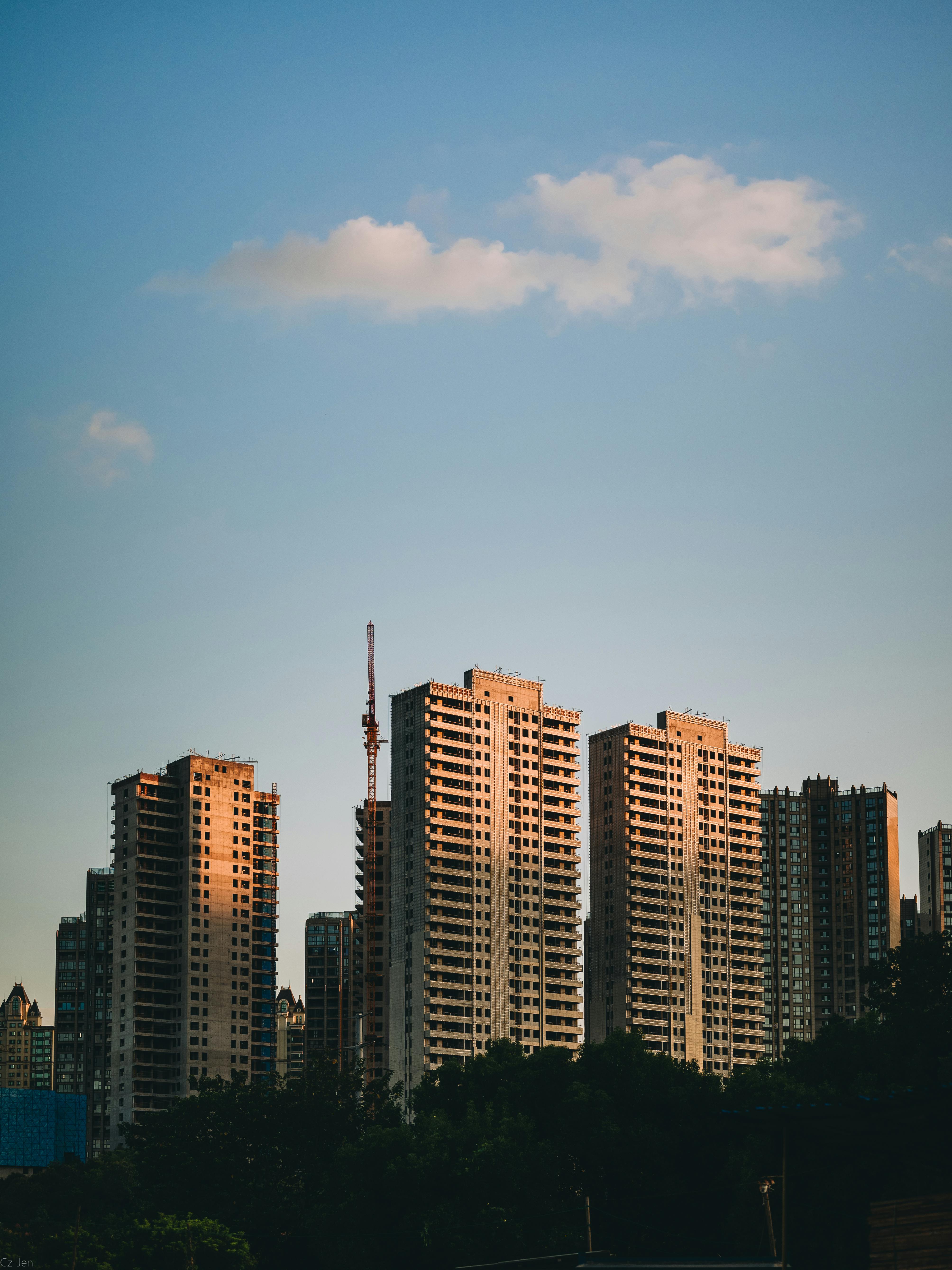 Modern skyscrapers bathed in warm sunset light create a serene urban skyline.