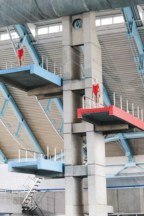 Athletes in Red Swimsuits Standing on Diving Tower