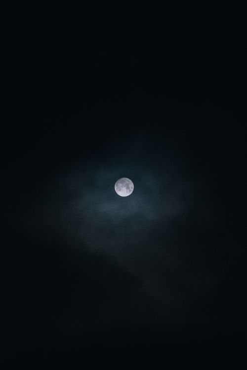 Free A full moon glowing in a partially clouded night sky over Yakutsk, Russia. Stock Photo