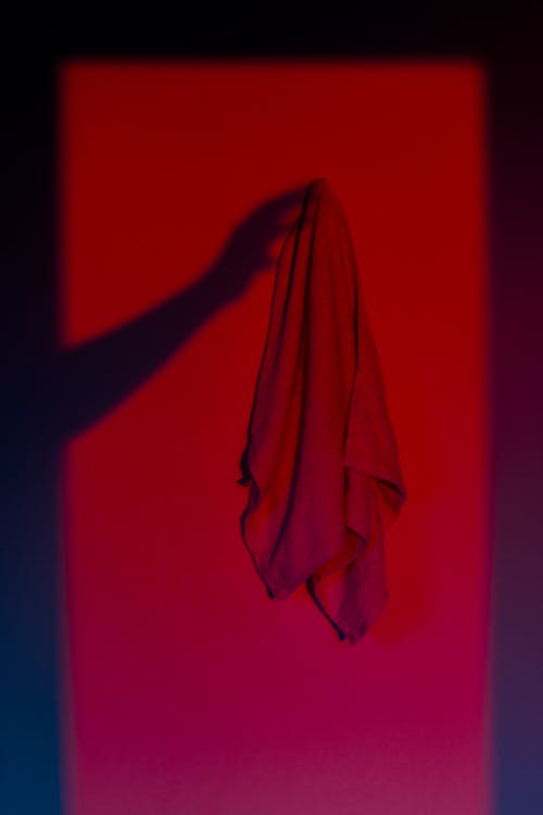 Person Hand Reaching Towel Hanging on Wall