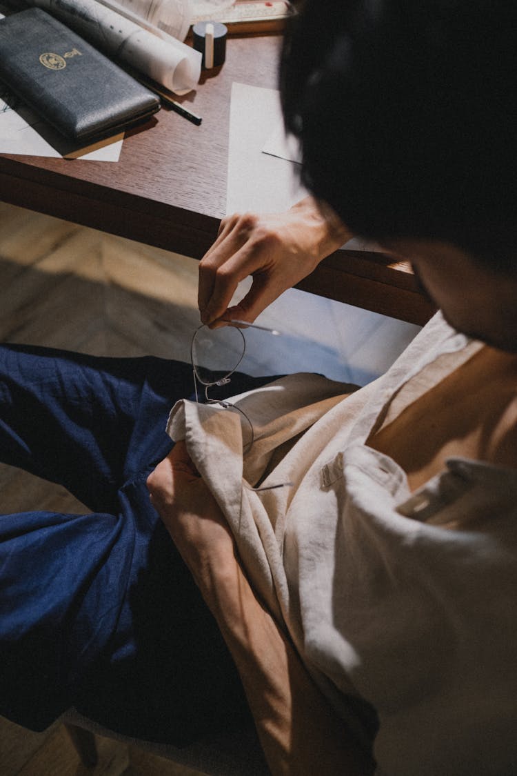 Adult Man Cleaning Glasses With His Shirt