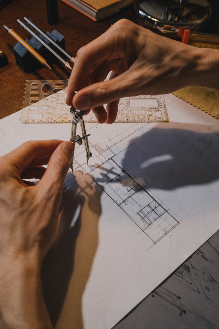 Man Hands Holding Compass Over Sketch