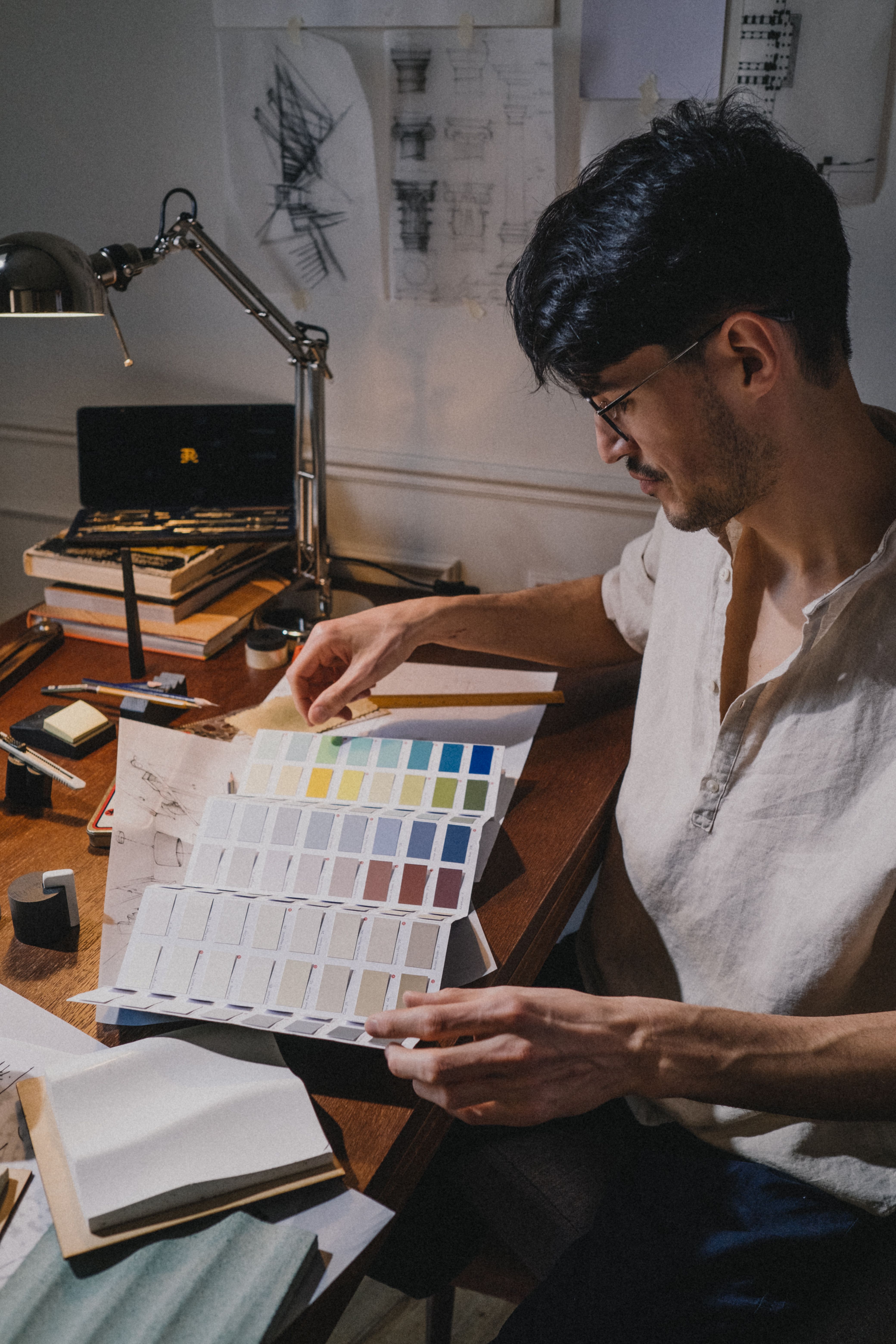 A designer comparing colours from a printed palette at a desk