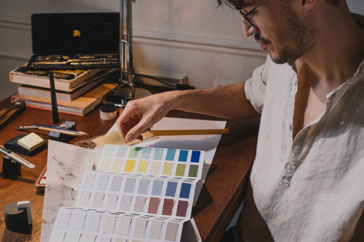 A designer comparing colours from a printed palette at a desk