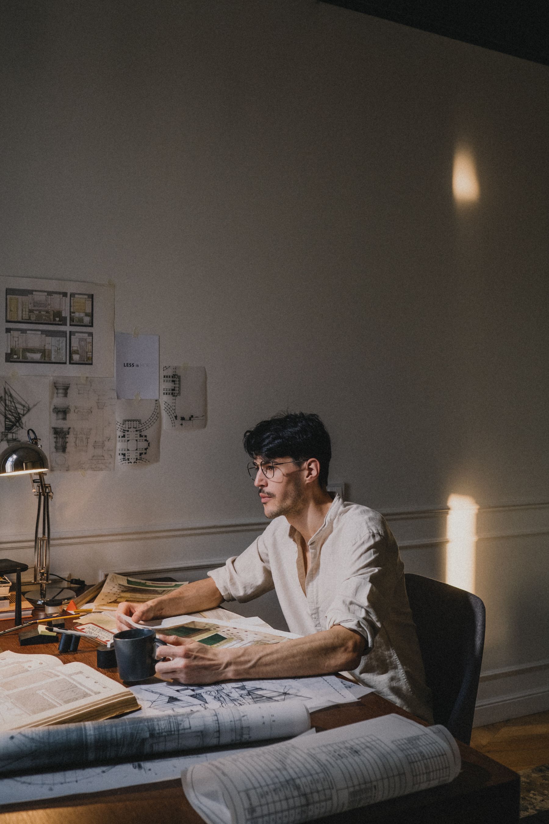 Designer working at a desk in strong natural light