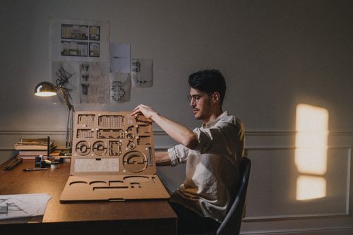 Free A focused architect working on a design at home with ambient daylight. Stock Photo