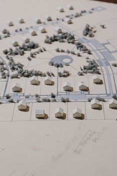 Detailed cardboard architectural model depicting houses, roads, and greenery.