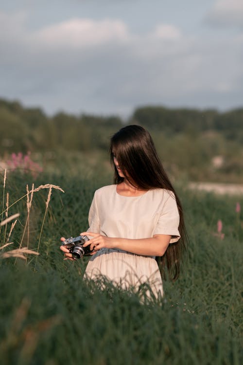 Woman in Beige Dress on Tall Grass Field