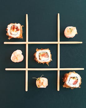 Creative sushi tic tac toe game with chopsticks on a dark background.