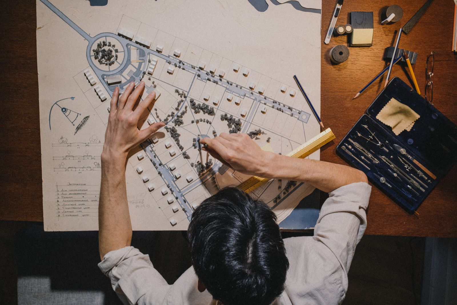 Overhead view of a drafting desk with a site plan and survey instruments — photo by Ron Lach on Pexels