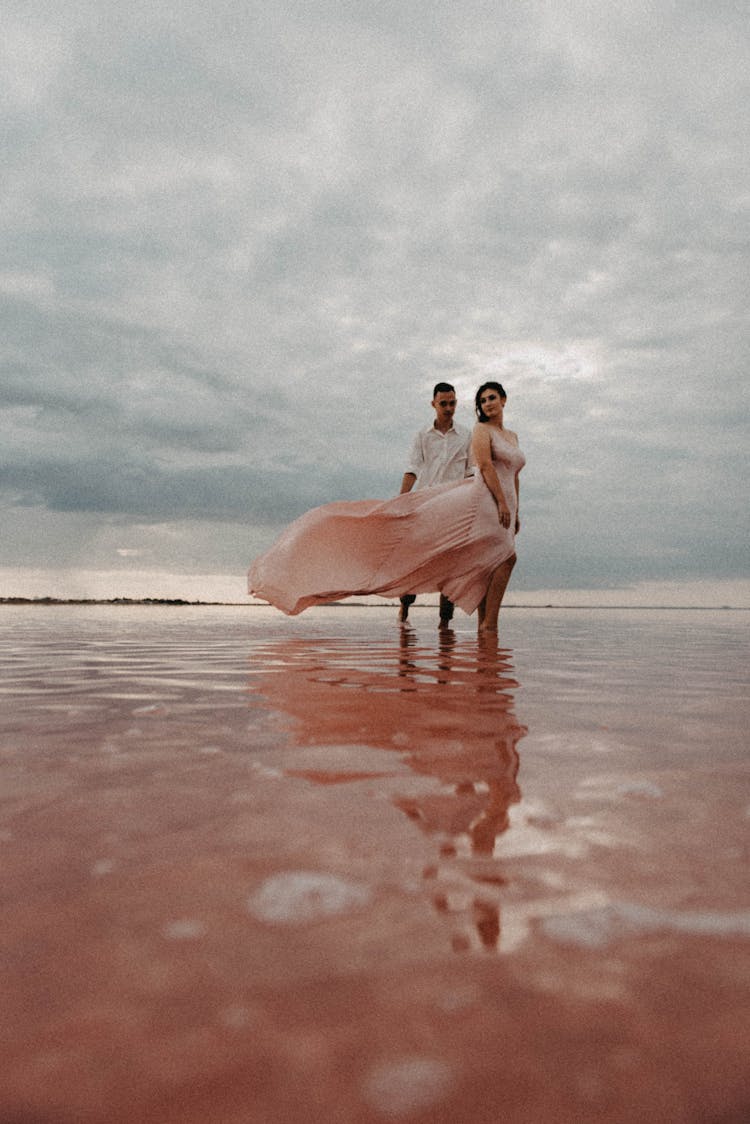 Man And Woman Walking Together On Beach