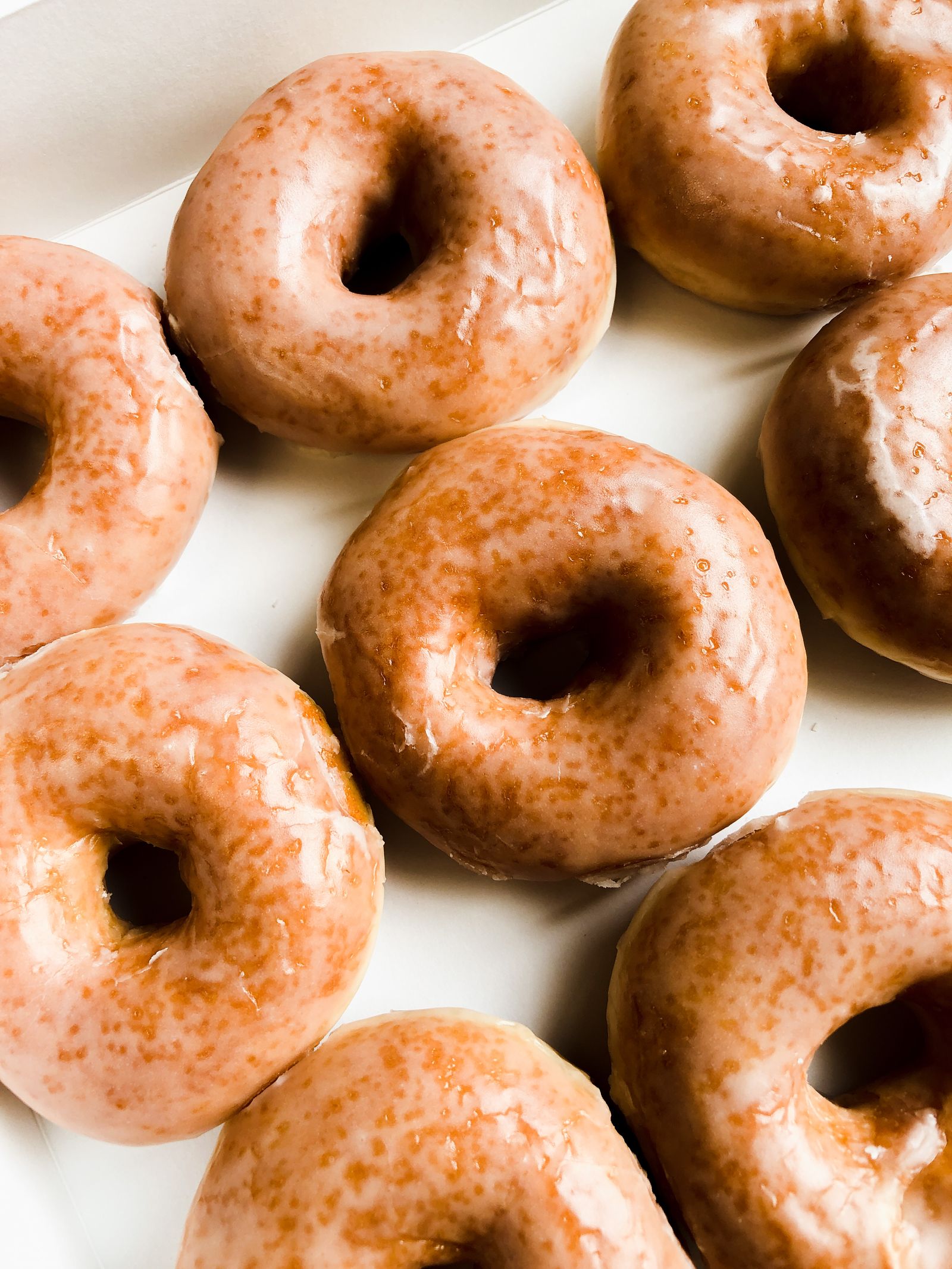 Glazed donuts arranged on a white tray