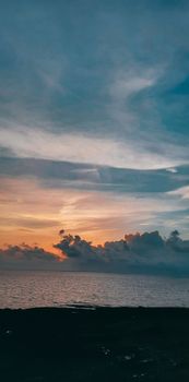 Peaceful sunset over the ocean with colorful clouds and tranquil sea view.