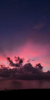 Vibrant twilight sky with pink and blue hues over the calm ocean, perfect for serene backgrounds.
