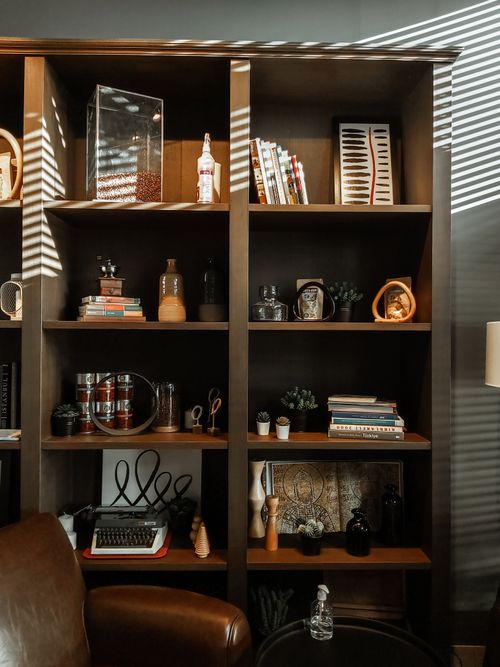 Free Well-organized bookshelf in a stylish home setting, featuring books and decorative items. Stock Photo