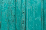 西班牙阿圭梅斯，一扇旧绿松石门的特写，门上的油漆已经剥落，纹理质朴
