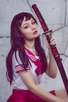 一位身穿水手服的年轻女子手持武士刀，展现了时尚与文化的融合