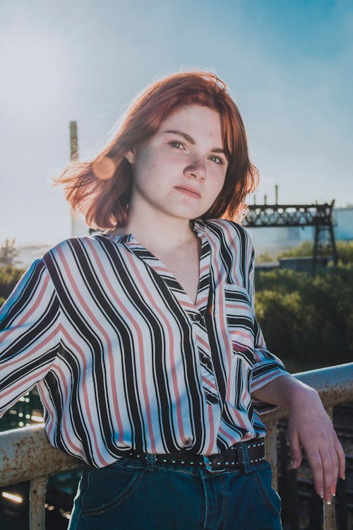 Woman in Sleeve Shirt Leaning on Metal Railing