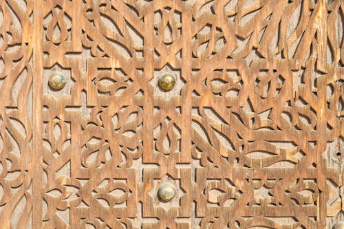 Sculpted Wooden Door with Brass Knobs