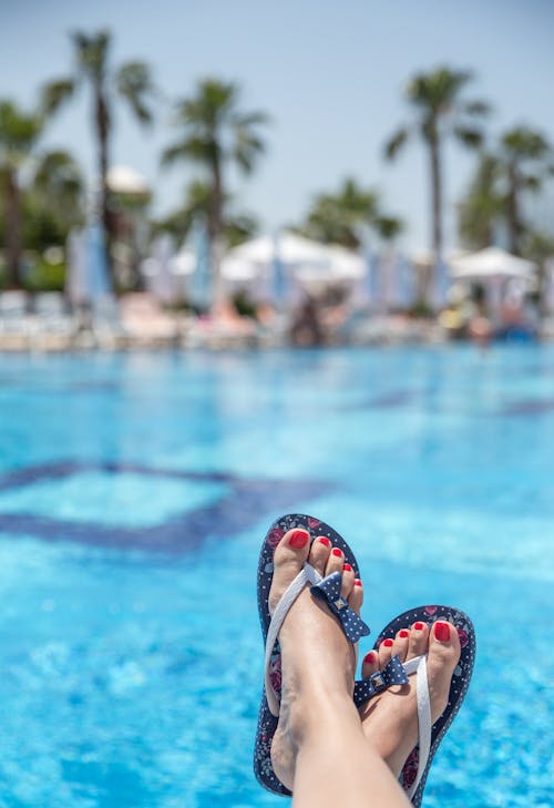 Person Wearing a Blue Slippers by the Pool