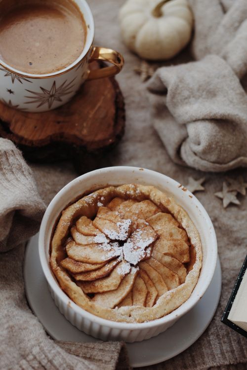 Free Warm apple pie with powdered sugar and coffee in a cozy winter setting. Stock Photo