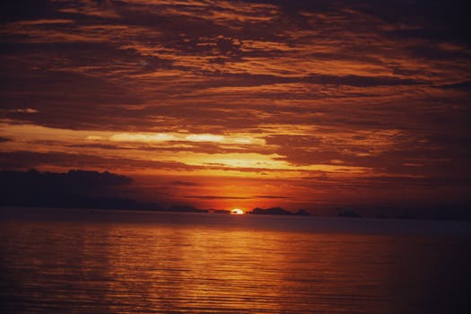 Gorgeous sunset over the ocean with a vibrant red sky reflecting on the water.