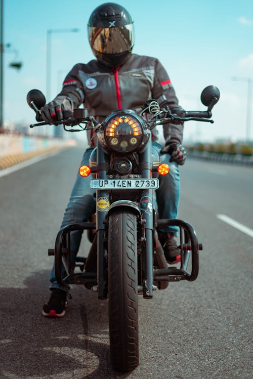 Person in Black Jacket with Helmet Riding a Motorcycle on Road