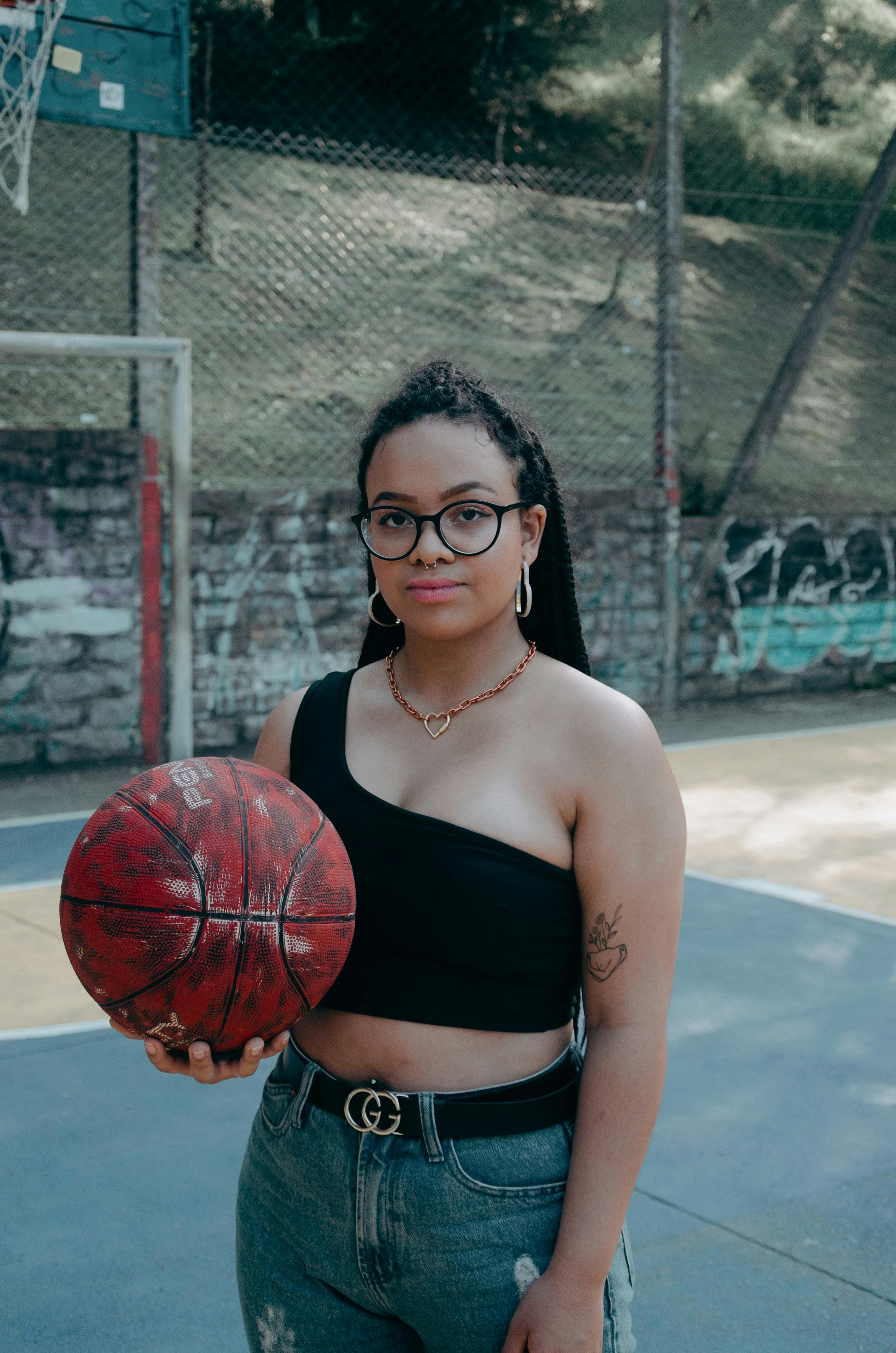 A Woman Wearing Black Cap While Holding Ball · Free Stock Photo