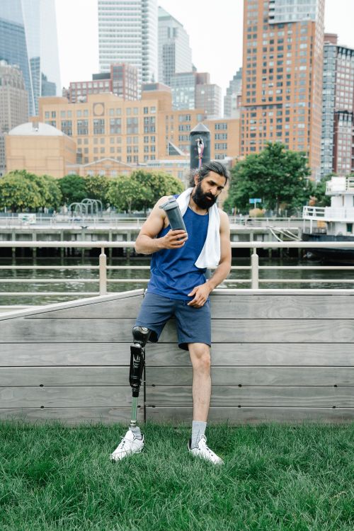 Free Man with a prosthetic leg in a park, promoting fitness and body positivity. Stock Photo