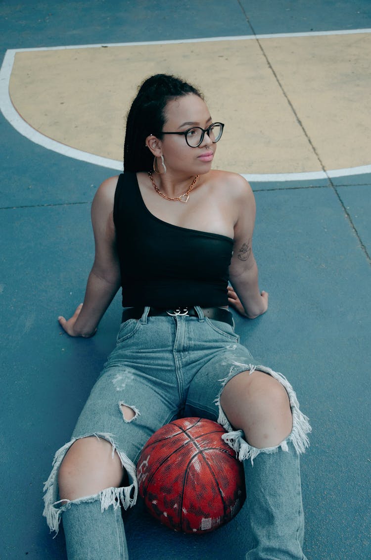 Brunette Woman Sitting On Basketball Court