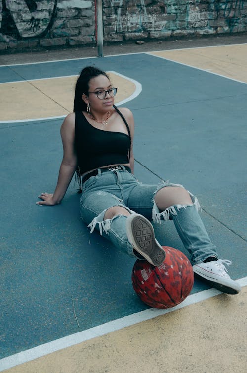 Free A Woman Sitting on a Basketball Court Stock Photo