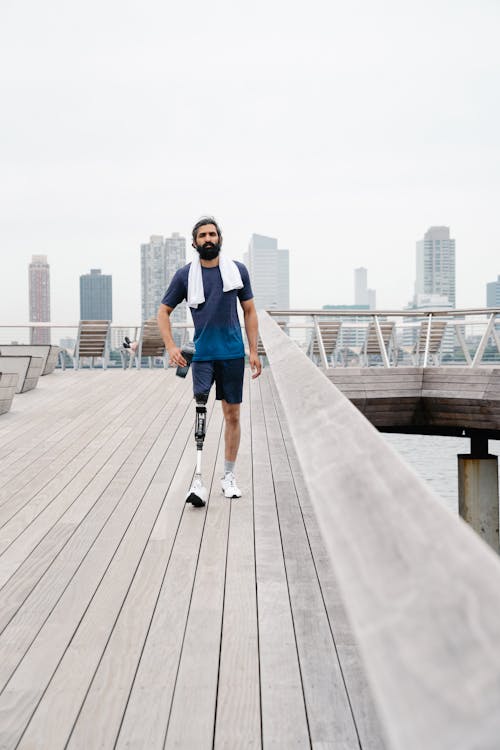 Male Amputee walking on Wooden Footbridge 