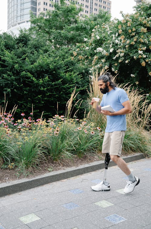 Man with Prosthetic Leg walking while drinking Coffee