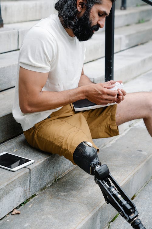 Man with Prosthetic Leg seated on Staircase