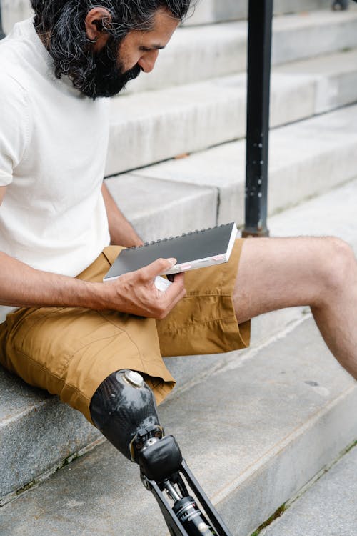 Man with Prosthetic Leg sitting on Staircase