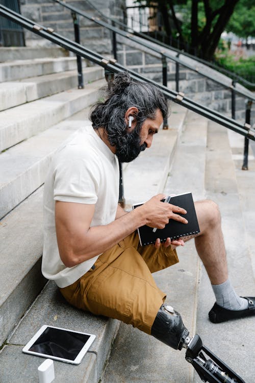 Man with Prosthetic Leg sitting on Staircase