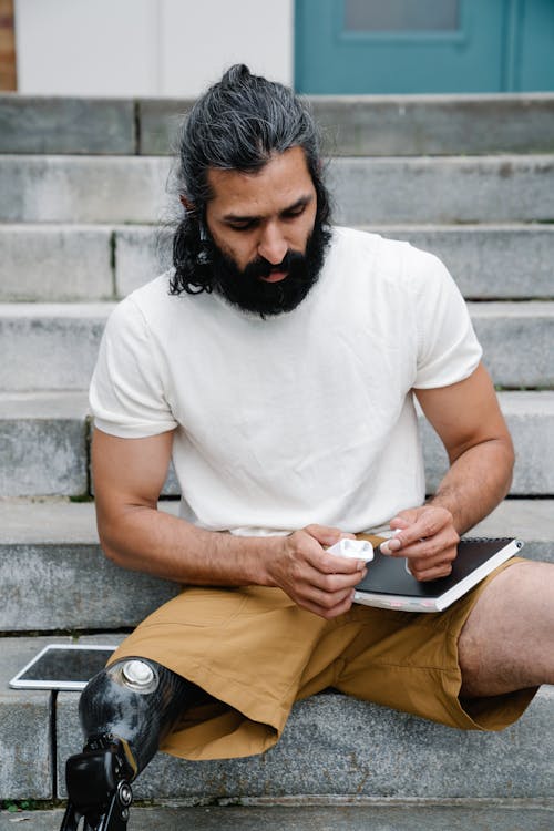 Man with Prosthetic Leg sitting on Staircase