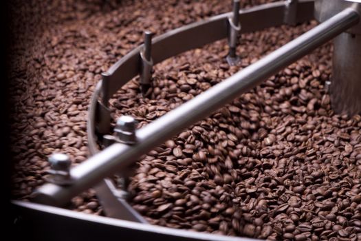 Detailed shot of coffee beans during the roasting process in a professional machine.