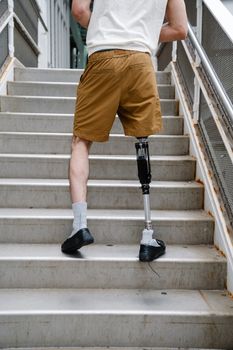A person with a prosthetic leg climbing a staircase, promoting disability awareness and inclusivity.