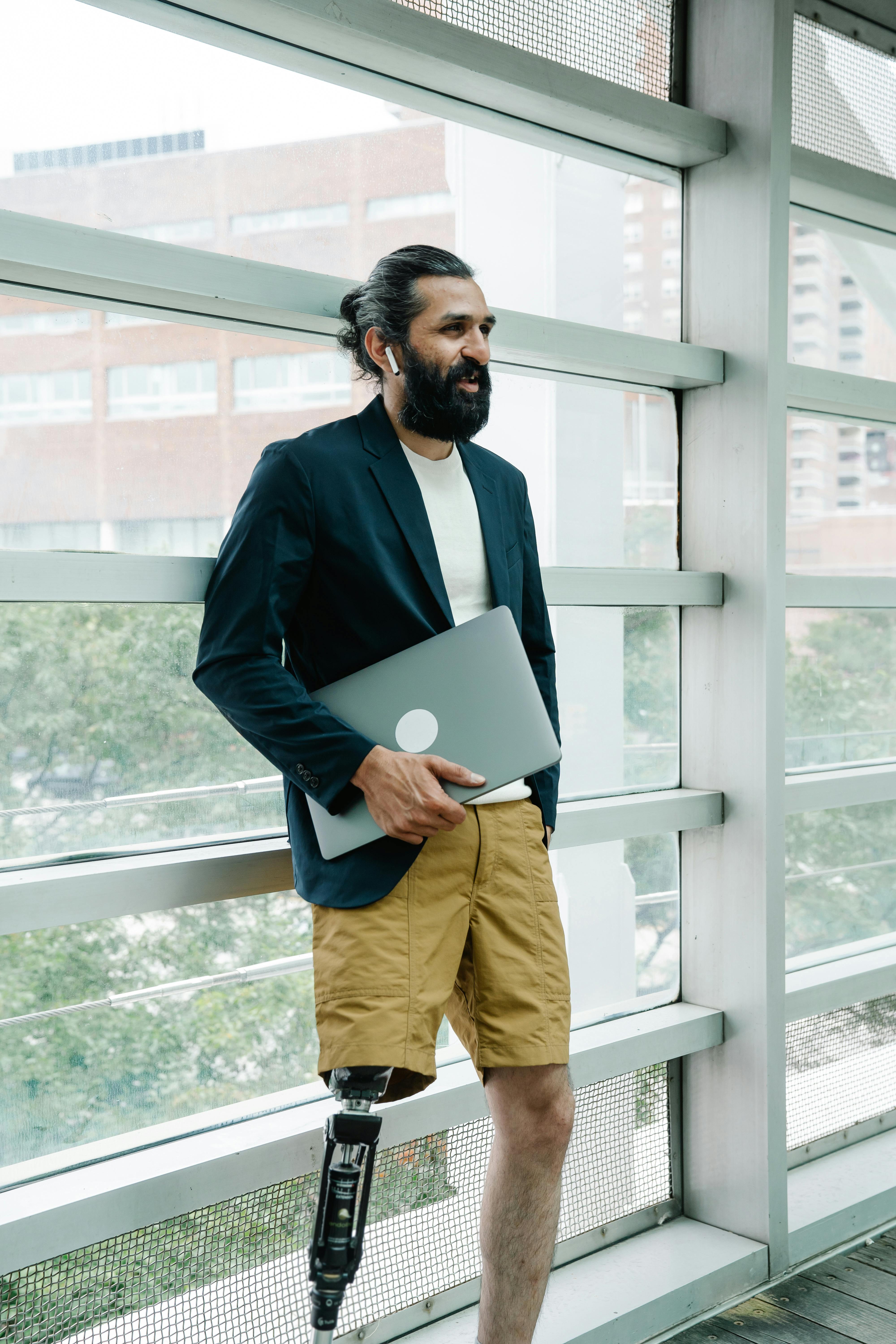 man with prosthetic limb carrying laptop