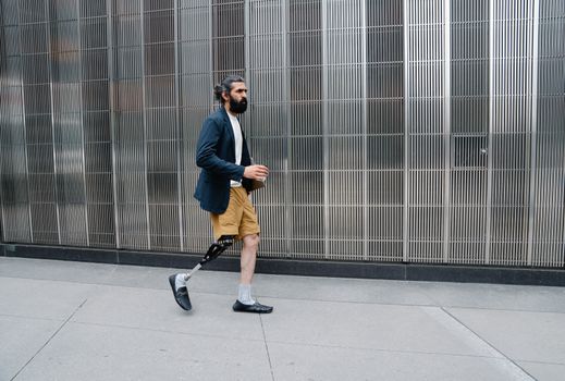 A man confidently walking with a prosthetic leg in an urban setting, showcasing empowerment and body positivity.