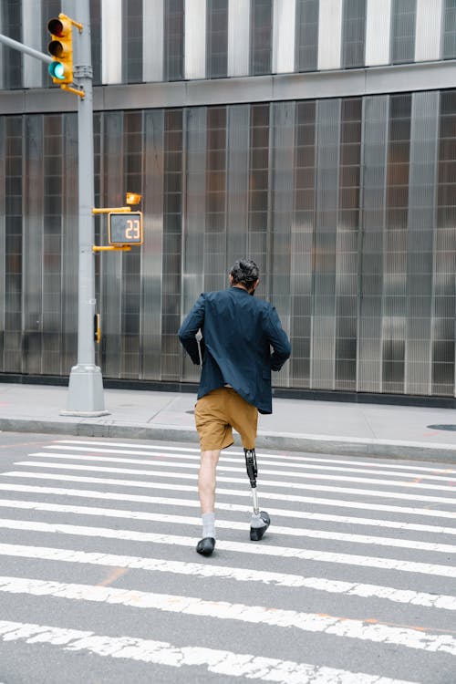 Backview of Man with Prosthetic Limb crossing Street